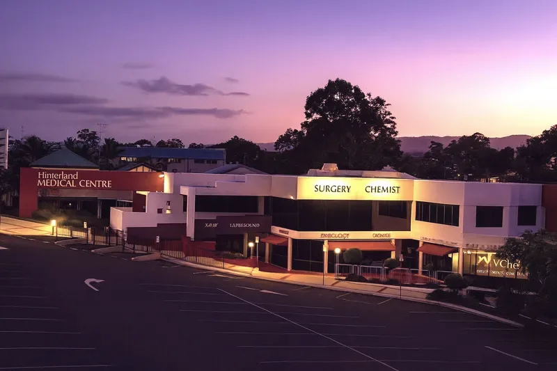 Hinterland Medical Centre on Price Street, Nerang, in the early evening, its signage lit and the hills behind.